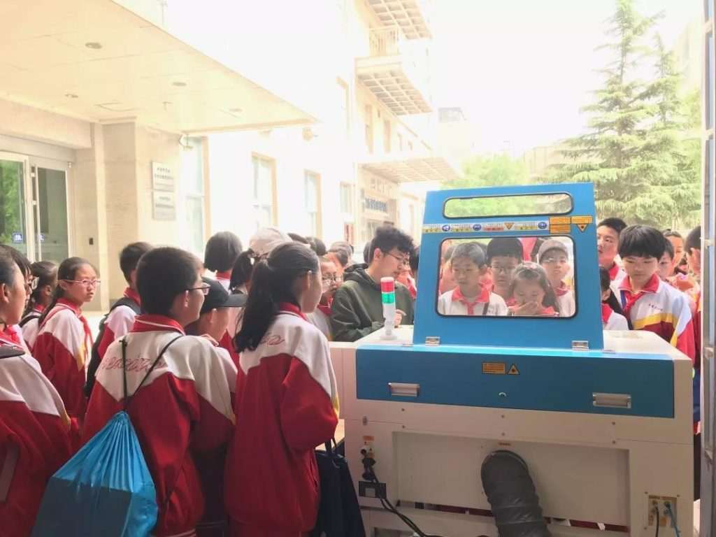 學(xué)生圍觀激光切割機(jī)